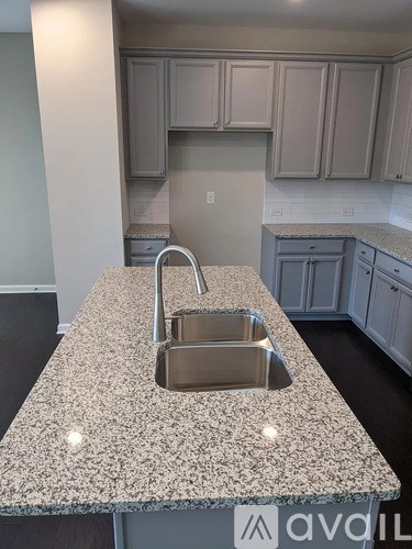 A granite countertop with a sink and faucet.