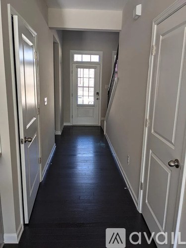 A hallway with white doors and a window.