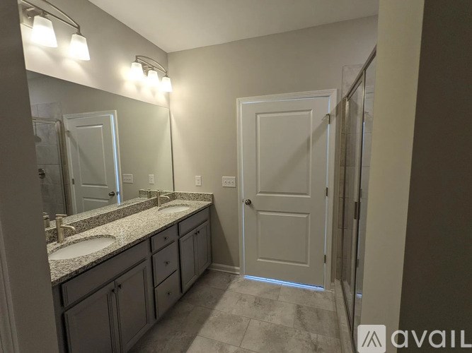 A bathroom with a sink, mirror, and lighting fixtures.