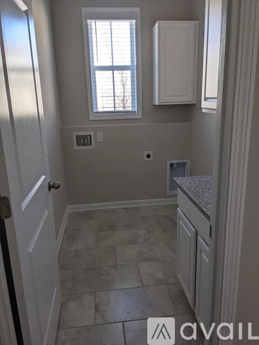 A kitchen with a tiled floor and white cabinets.