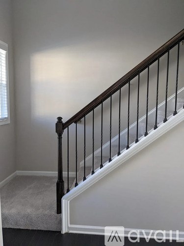 A staircase with a black railing and a carpeted floor.