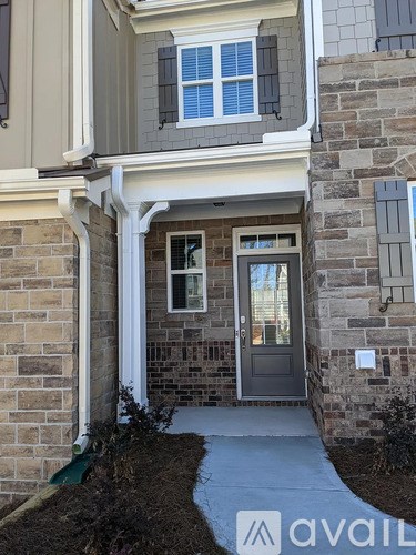 A house with a grey door and a window with white blinds.