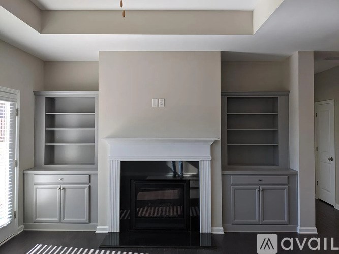 A modern living room with a fireplace and built-in shelves.