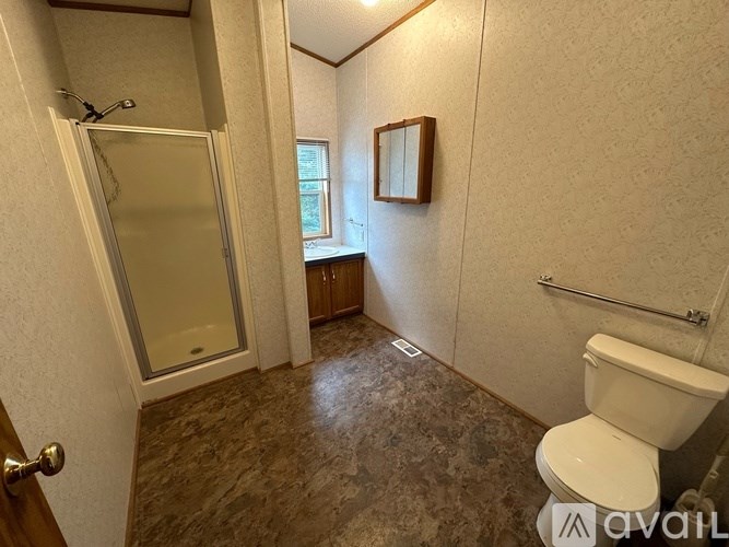 A bathroom with a toilet, sink, and shower.