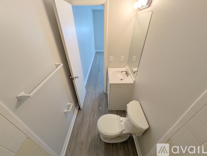 A bathroom with a toilet, sink, and mirror.
