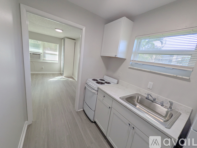 A kitchen with white cabinets and a stove top oven.