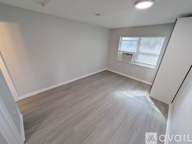A room with light grey walls and a wooden floor.