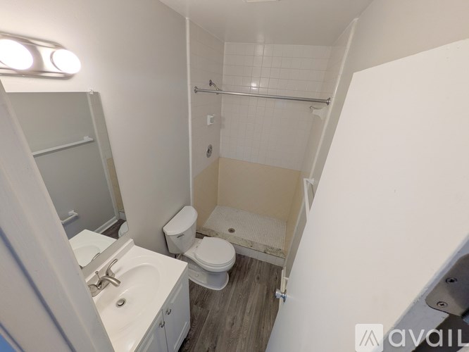 A small bathroom with a toilet, sink, and shower.