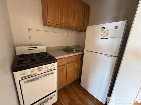 A white fridge in a kitchen with wooden cabinets.
