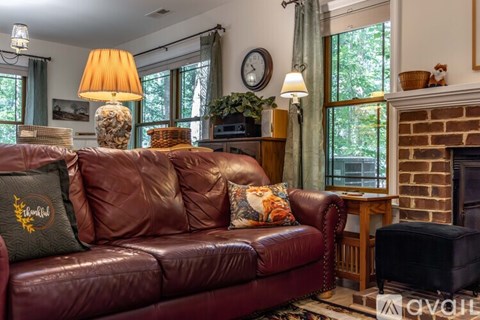 A living room with a red couch and a fireplace.