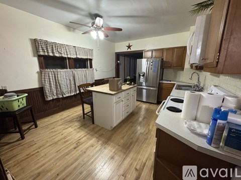 A kitchen with wooden floors and a ceiling fan.