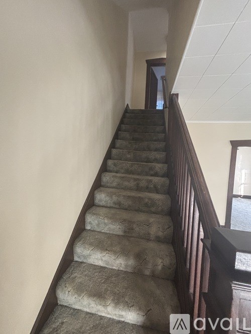 A staircase with a carpeted runner and wooden balusters.