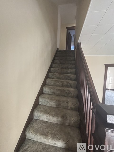 A staircase with a carpeted runner and wooden balusters.