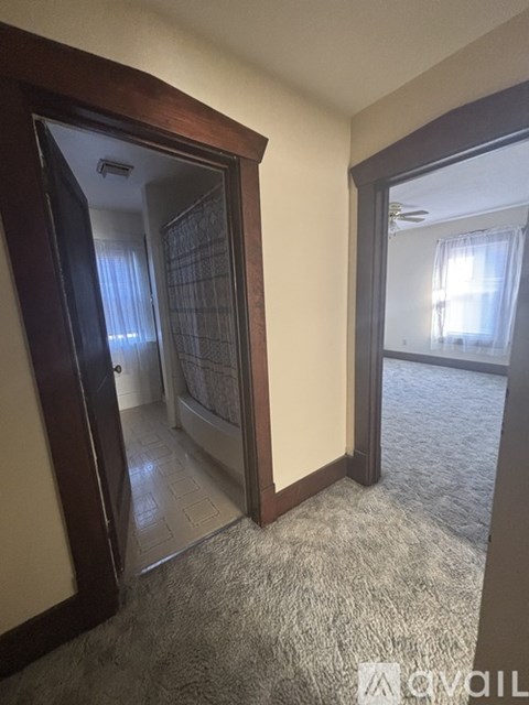 A room with a carpeted floor and a doorway leading to another room.