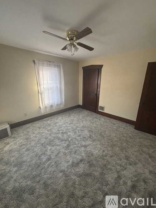 A room with a ceiling fan and a carpeted floor.