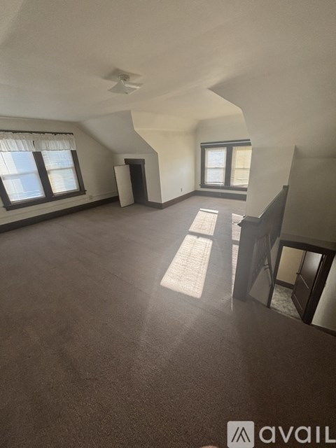 A spacious room with a window and a door.