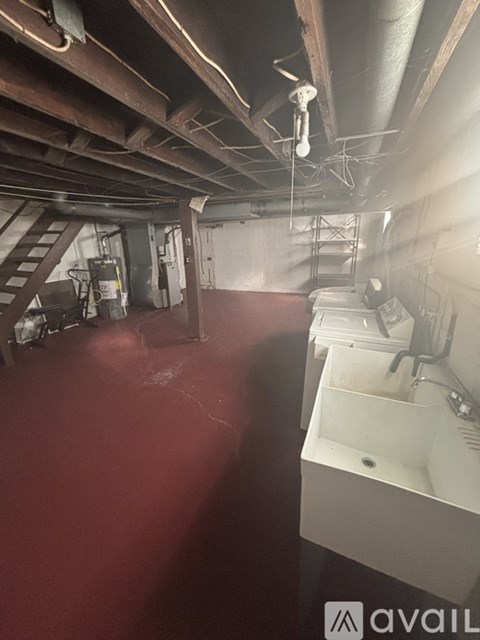A room with a red floor and a white sink.