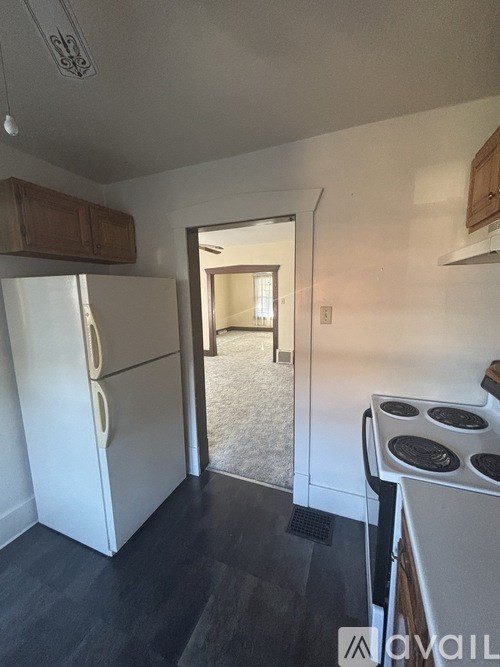 A kitchen with a white fridge and stove top oven.