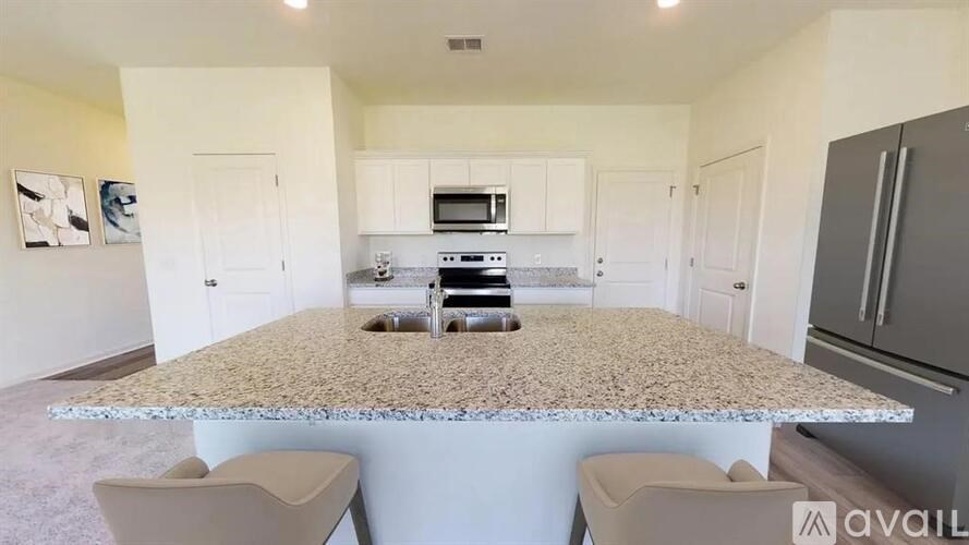 A kitchen with granite countertops and white cabinets.