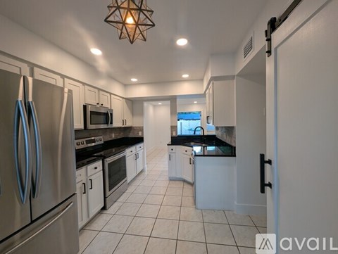 A kitchen with white cabinets and stainless steel appliances.