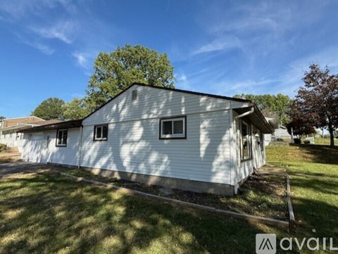 A house with a white siding and a grey roof is available for purchase.