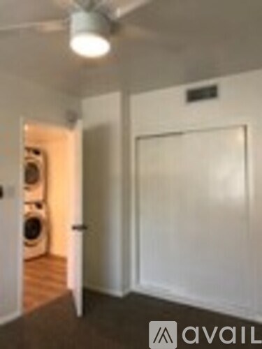 A room with a white door and a white wall with a black sign on it.