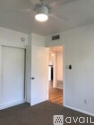 A room with a carpeted floor and a door on the left.