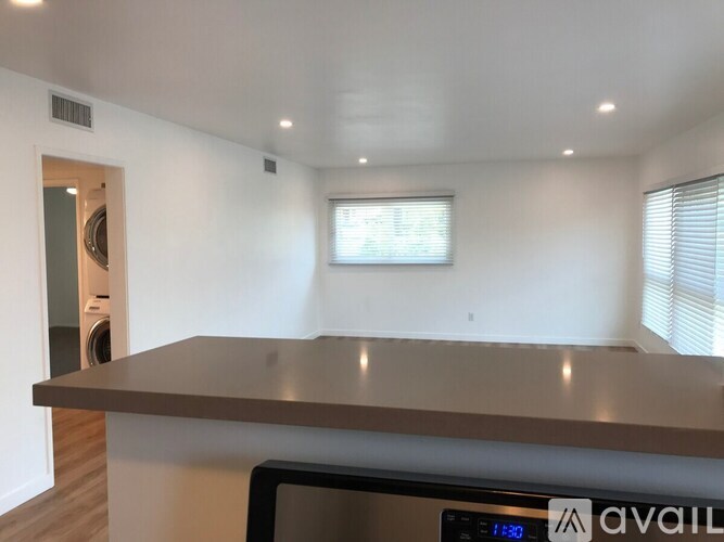 A kitchen counter with a digital clock showing 1:50.
