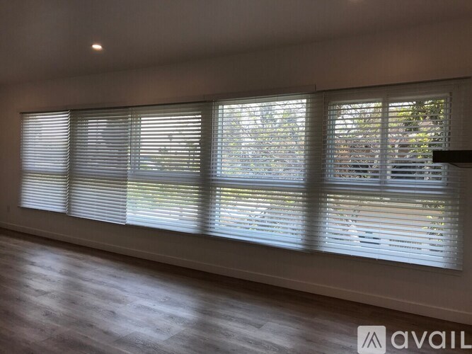 A room with a large window covered in blinds.