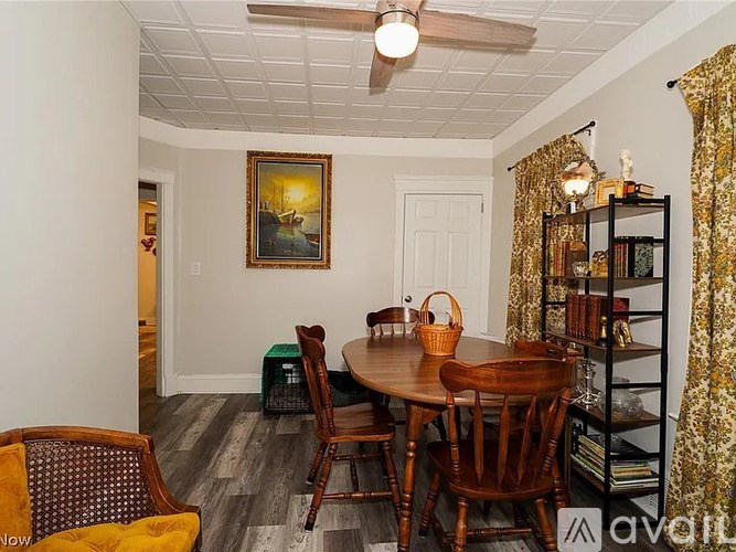 A dining room with a wooden table and chairs.