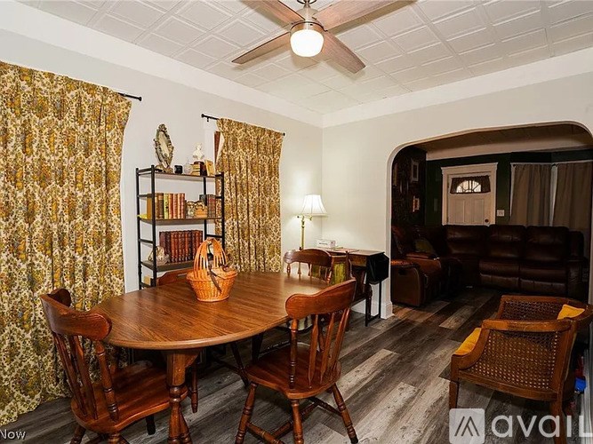 A room with a round wooden table surrounded by chairs.