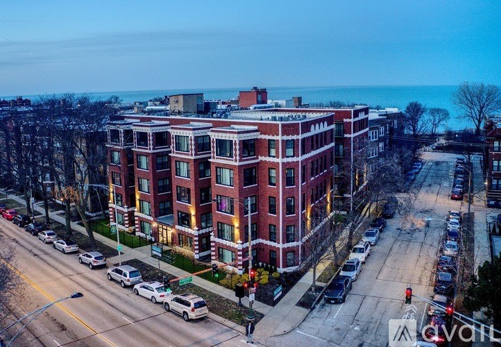 A red brick building with a parking lot in front of it.