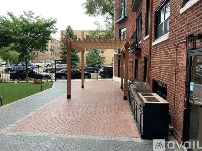 A brick walkway leads to a building with a black awning.