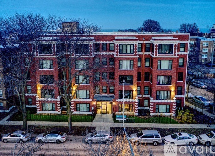 A large red brick building with a parking lot in front.