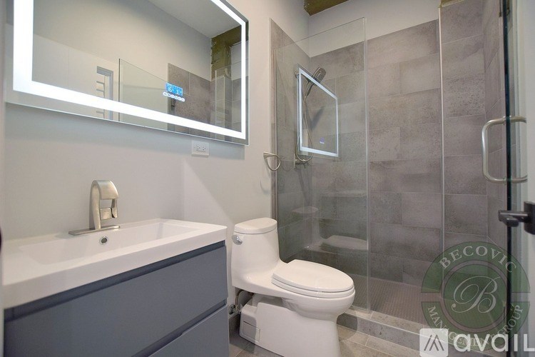 A modern bathroom with a white toilet and a glass shower stall.