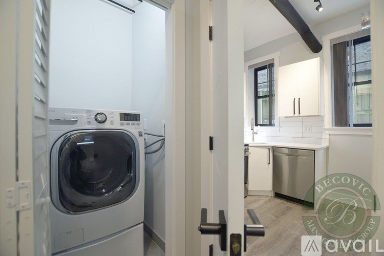 A modern kitchen with a washing machine in the doorway.