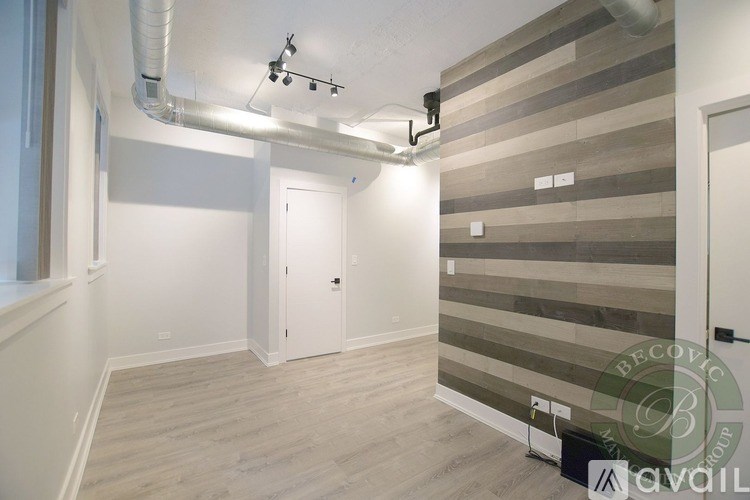 A room with a striped wallpaper and a white door.