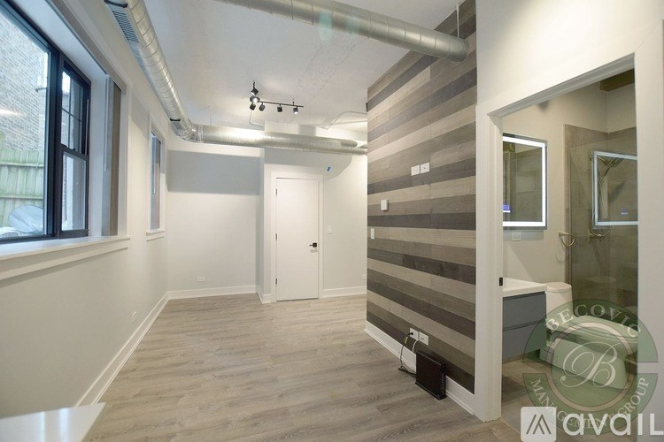 A room with a striped wallpaper on the wall and a white door.