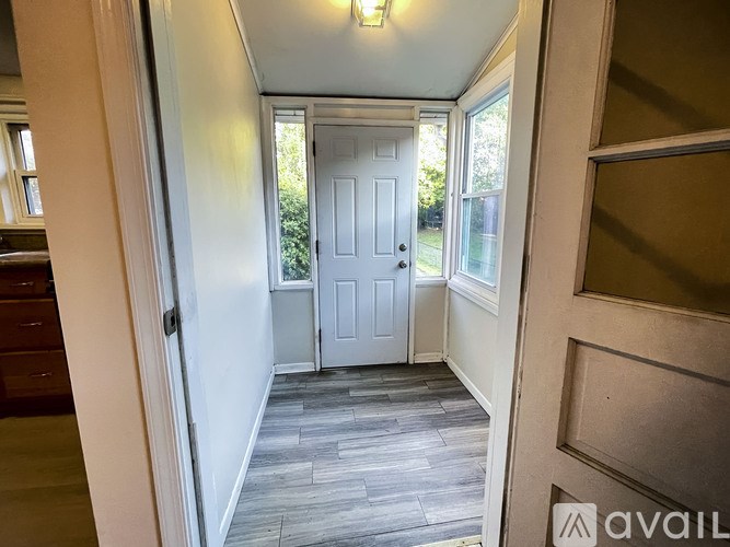 A hallway with a white door and a grey floor.