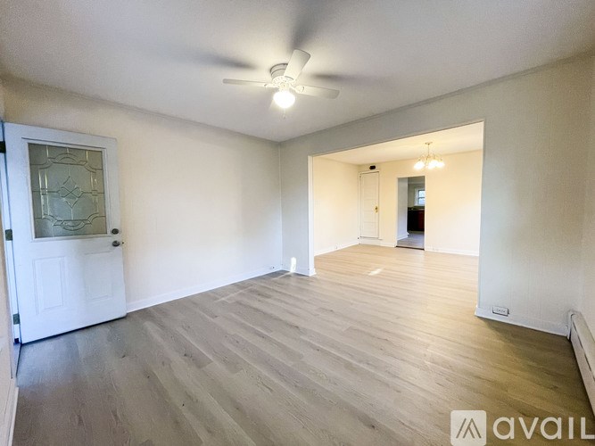 A room with wooden flooring and a ceiling fan.