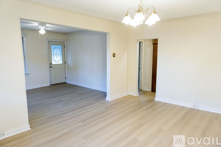 A room with wooden flooring and a chandelier.