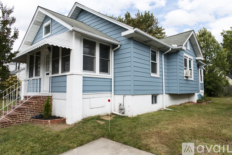 A blue house with white trim and a red fire hydrant in front.