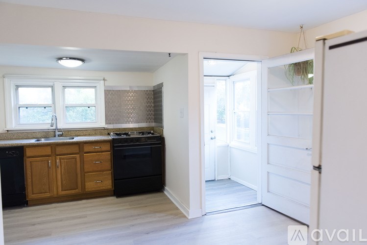 A kitchen with black appliances and wooden cabinets.