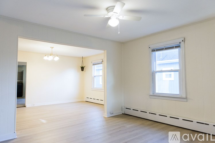 A spacious room with a window and a ceiling fan.