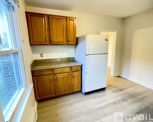 A kitchen with wooden cabinets and a white refrigerator.