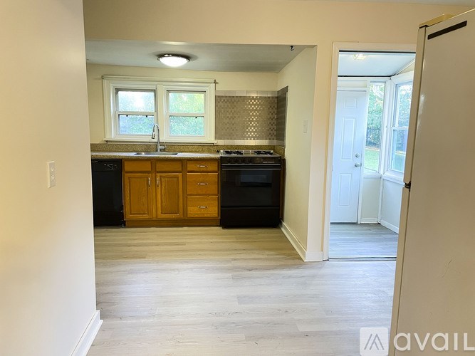 A kitchen with wooden cabinets and black appliances.