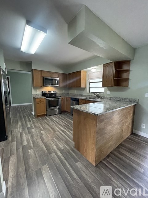 A kitchen with wooden cabinets and a marble countertop.