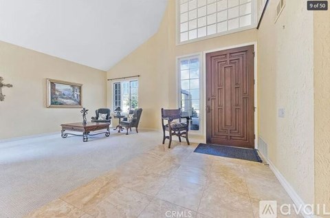A living room with a wooden door and a painting on the wall.