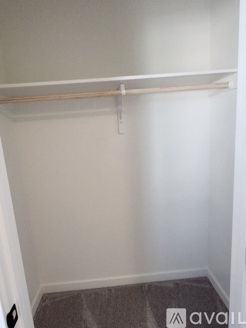 A small, empty room with a carpeted floor and a white wall.