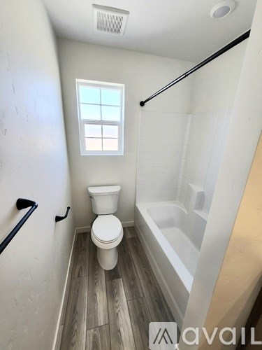 A backyard with a fence and green grass.